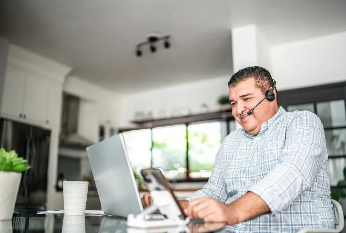 Man working on laptop with headset