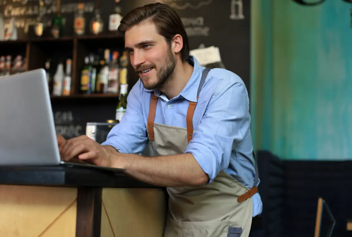 Barista using laptop in a cafe